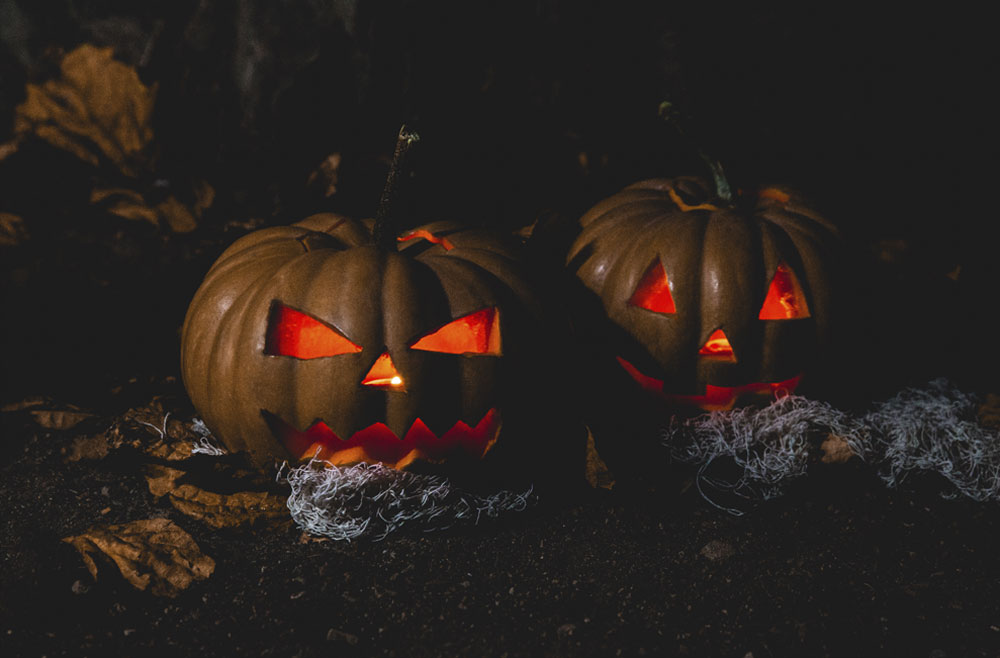 Two pumpkins glowing in the dark